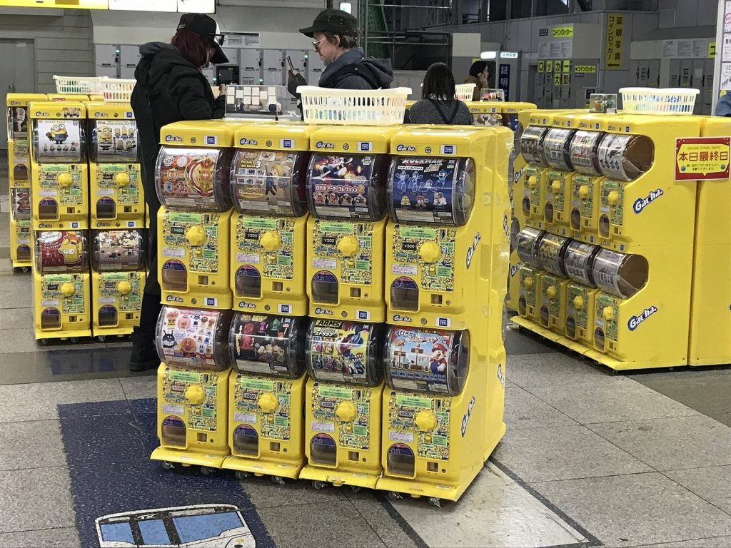 Yellow capsule toy machines lined up inside Akihabara JR Station